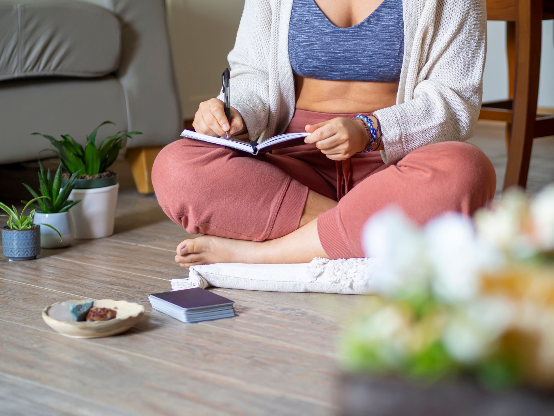 Woman journaling and manifesting in a diary as a routine at home.